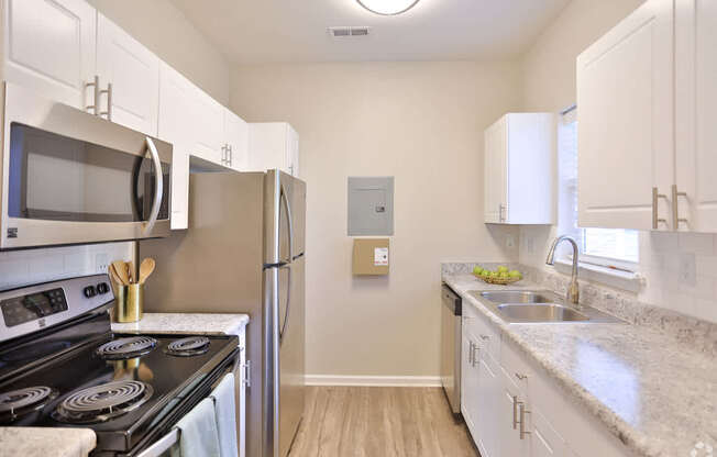 A kitchen with white cabinets and a black stove top.