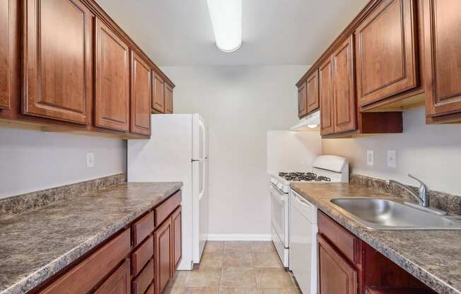 a kitchen with white appliances and wood cabinets