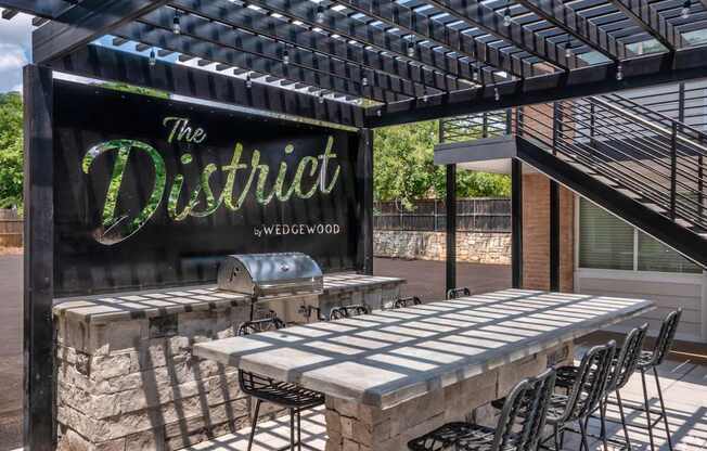 A sign that says "The District" is displayed in front of a patio area.