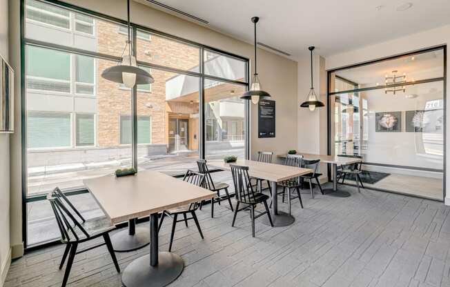 a seating area with tables and chairs in front of a window