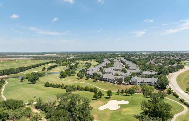 A golf course with a large building in the background.