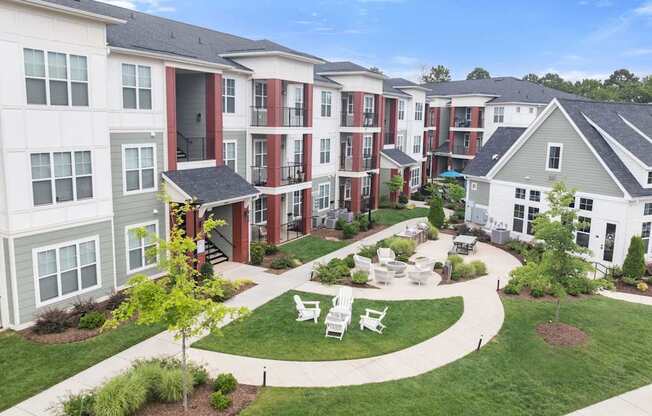Apartment complex with a green lawn and trees.