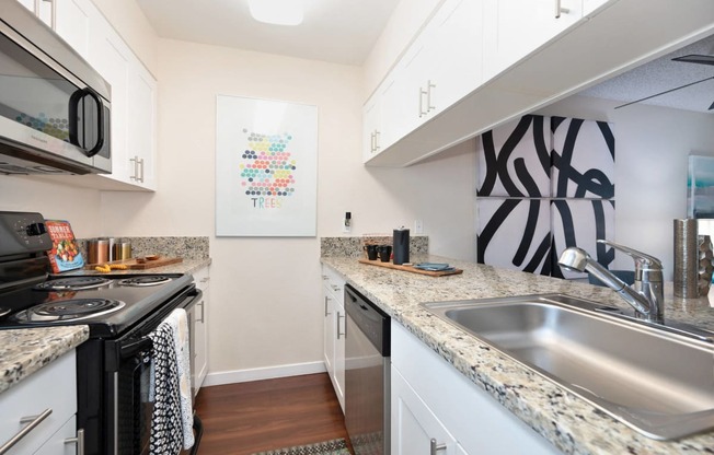 a kitchen with granite counter tops and a stainless steel sink