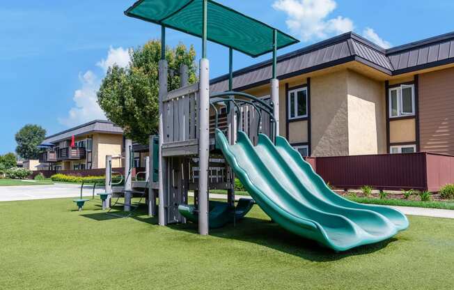 a playground with a slide in front of a building