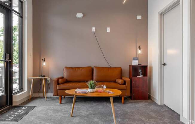 A living room with a brown leather couch and a wooden coffee table.