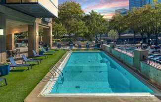 A rectangular pool with a metal railing and a concrete floor.