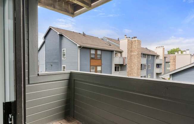 A balcony with a view of apartment buildings.