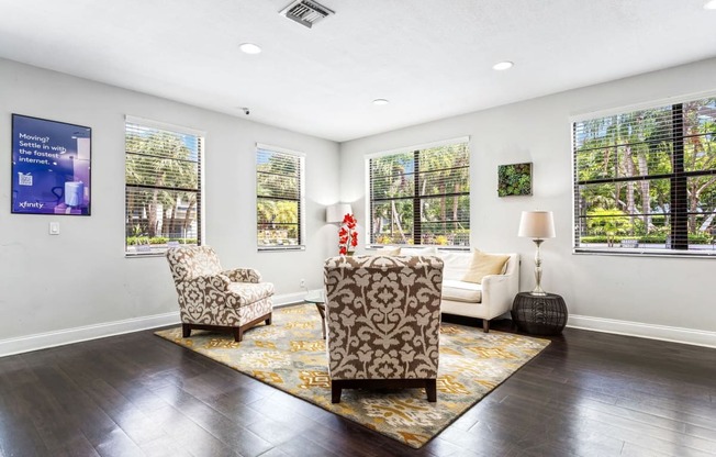 a living room with a couch and two chairs and windows at Waterford Park Apartment Homes, LLC, Lauderhill Florida