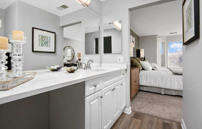 an open kitchen with white cabinets and a bedroom with a bed