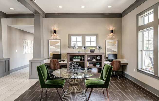 a living room with a round table and green chairs