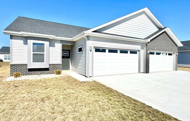 A house with a grey roof and a white garage door.