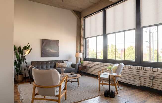 a living room with large windows and a brick wall at The Draper, Missouri