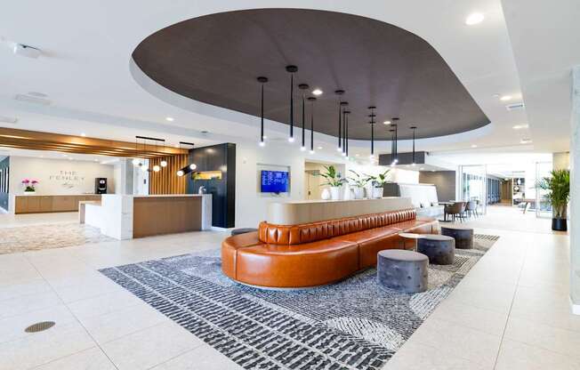 A reception area with a curved ceiling and a long orange couch.