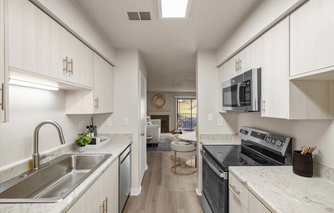 A kitchen with white cabinets and a black stove top oven.