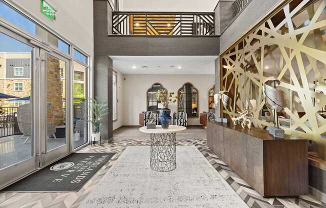 A lobby with a black and white rug and a wooden reception desk.