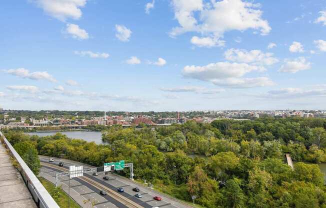 A highway with cars and a green sign in the distance.