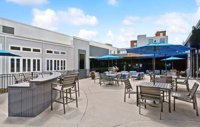 a patio with tables and chairs and umbrellas in front of a building at The Tannery, Glastonbury, Connecticut