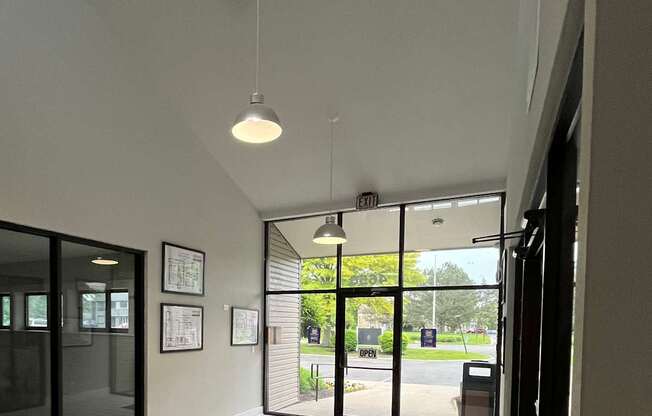 A white tiled wall with a black shelf and a window.
