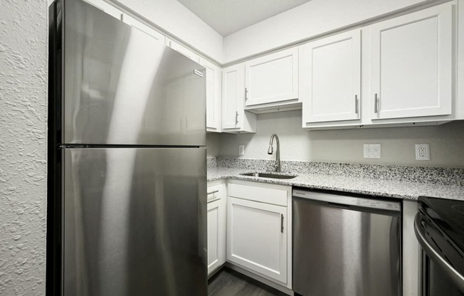 a kitchen with white cabinets and a stainless steel refrigerator at Southridge, Kansas City, KS, 66103