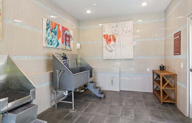 A kitchen area with a stainless steel sink and a painting on the wall.