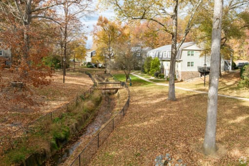 a backyard with trees and a fence and a house