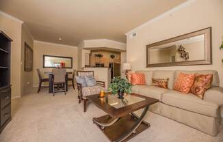 A living room with a couch, coffee table, and a large mirror on the wall.