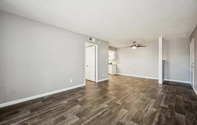 A room with wooden flooring and a ceiling fan.