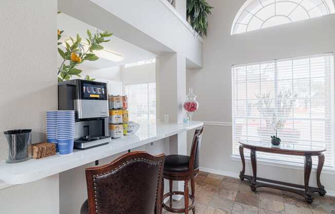 a kitchen with a coffee machine and a counter with chairs