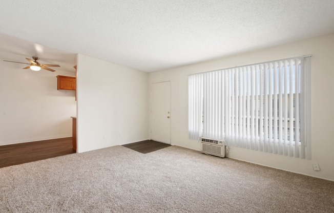 a bedroom with a large window and a ceiling fan