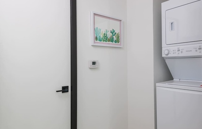 A white washing machine sits next to a white door.