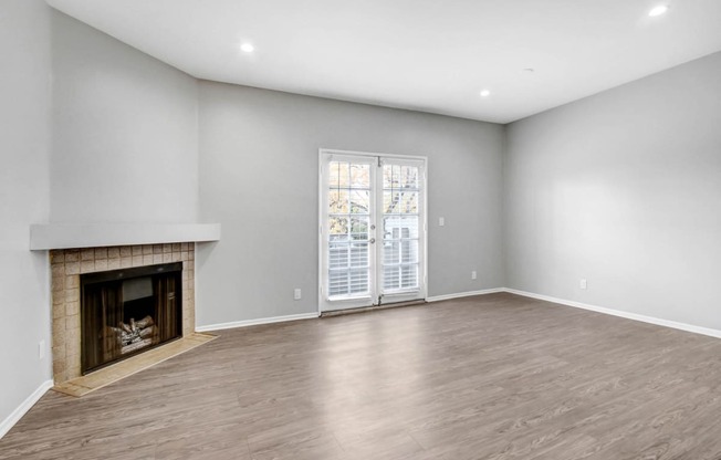 a living room with a fireplace and a door to a patio