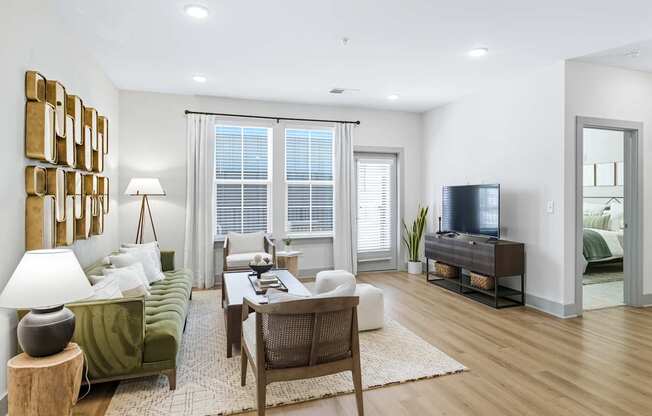 A living room with a green couch, a wooden table, and a television.