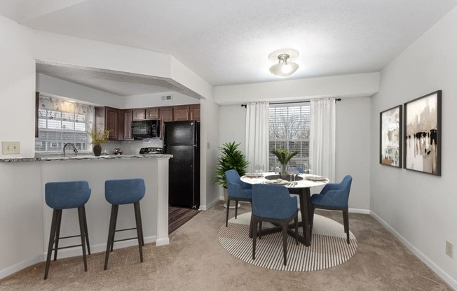 our apartments offer a kitchen and dining area with a table and chairs