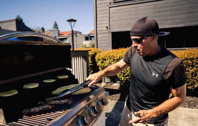 a man grilling food on a barbecue grill