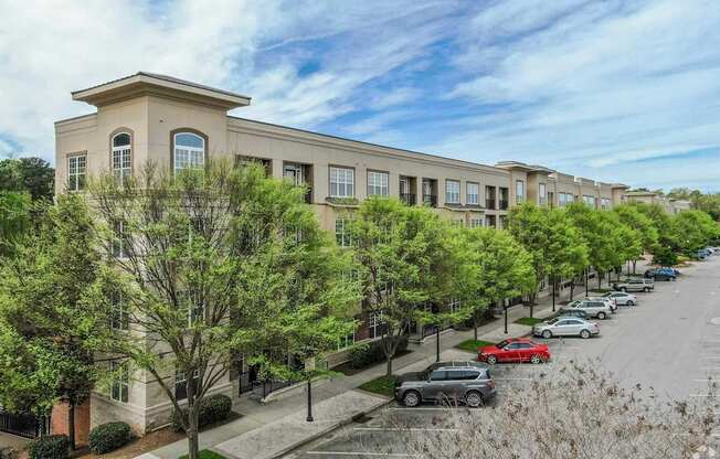 A row of townhouses with cars parked in front.
