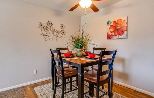 a dining room with a table and chairs and a ceiling fan