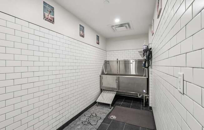 A white tiled bathroom with a sink and a toilet.