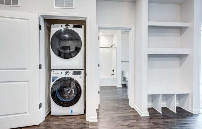 a white washer and dryer in a room with white walls and a door