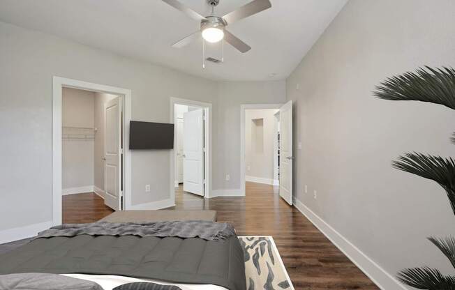 A bedroom with a bed and a ceiling fan.