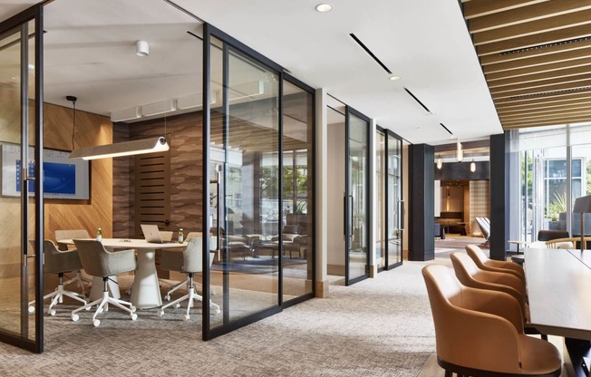 a conference room with glass walls and a table with chairs