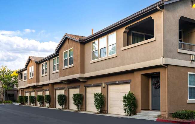 A row of houses with garages and front yards.