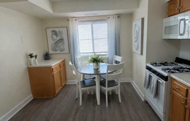 A kitchen with a table and chairs in the middle of the room.