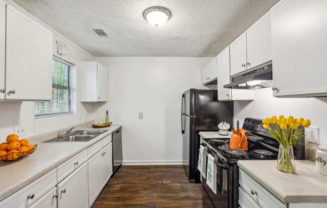 a kitchen with white cabinets and a black refrigerator