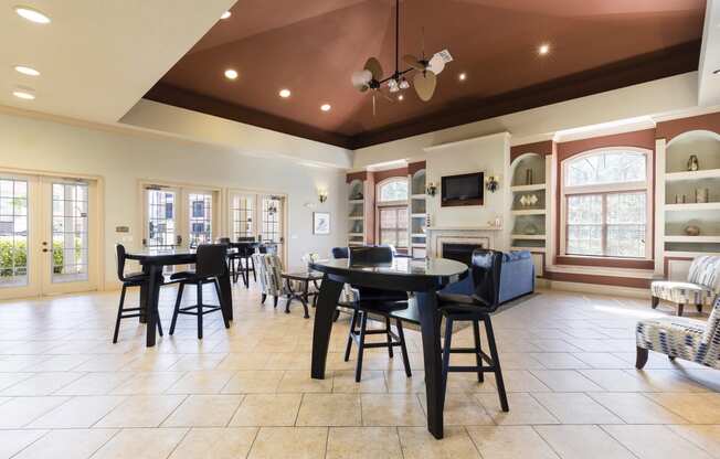 Rapallo Apartments community clubhouse seating area with 2 bar tables and 2 chairs at each table.
