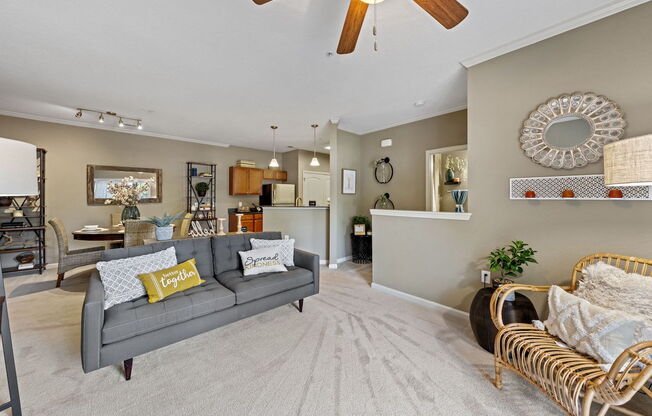 large Fenwyck Manor apartment home living room, dining room, and kitchen with plush carpeting and ceiling fan