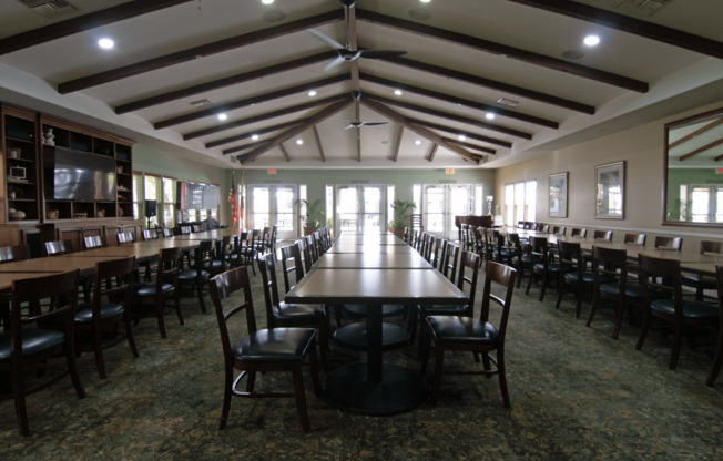 A large room with tables and chairs.,A large room with tables and chairs.
