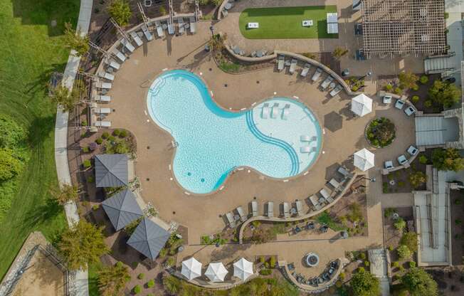 an overhead view of a swimming pool at a resort with umbrellas