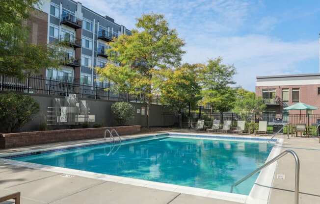 A swimming pool surrounded by trees and buildings.