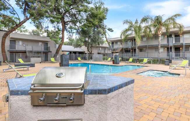 A grill is on a table next to a pool.