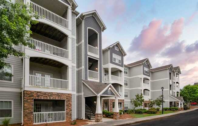 Apartment building with balconies and a stone facade.